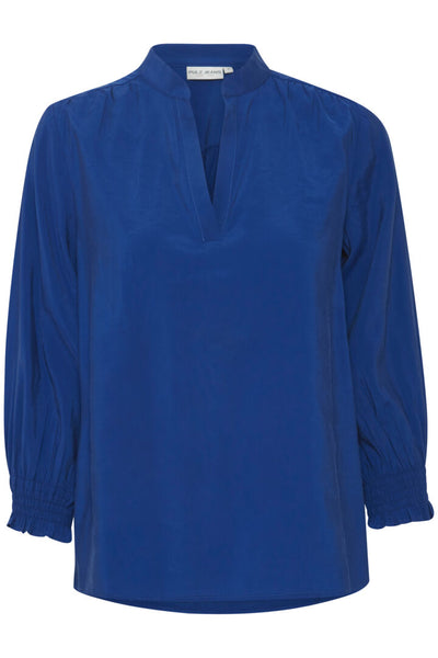 The Charlene is a blouse for those who just want something plain coloured yet stylish to update their wardrobe.  This useful staple comes in a beautiful cobalt or "sodalite" blue or cloud white.  It is the shape du jour - colourless, v necked, long full sleeves with ruched deep elasticated cuffs. Plain but pretty at the same time  80% Modal; 20% Polyester  30 degree machine washable   