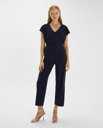front view showing model wearing ankle length silky trousers with high heels and blue top