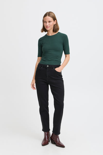 Woman wearing BY Loetta black jeans with green tshirt on a white background 