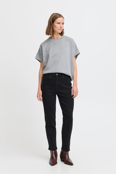 Woman wearing BY Loetta black jeans with gray top on a white background