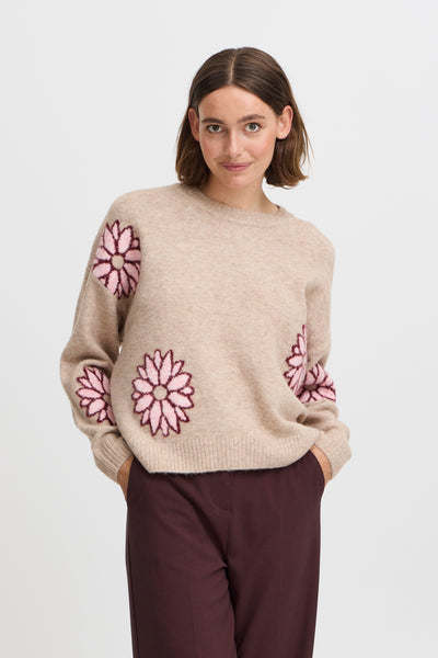 Woman wearing BY Omea sweater with pink floral patterns on a white background