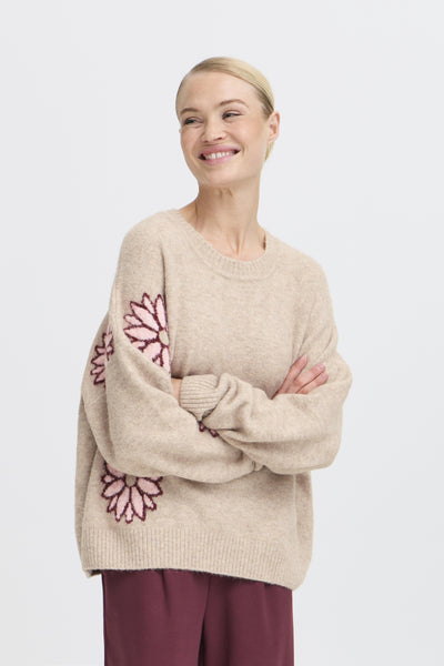 Woman wearing BY Omea sweater with pink floral patterns on a white background