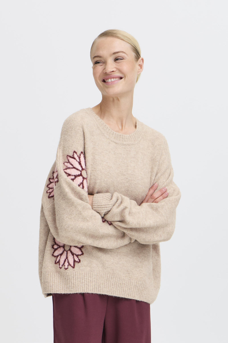 Woman wearing BY Omea sweater with pink floral patterns on a white background
