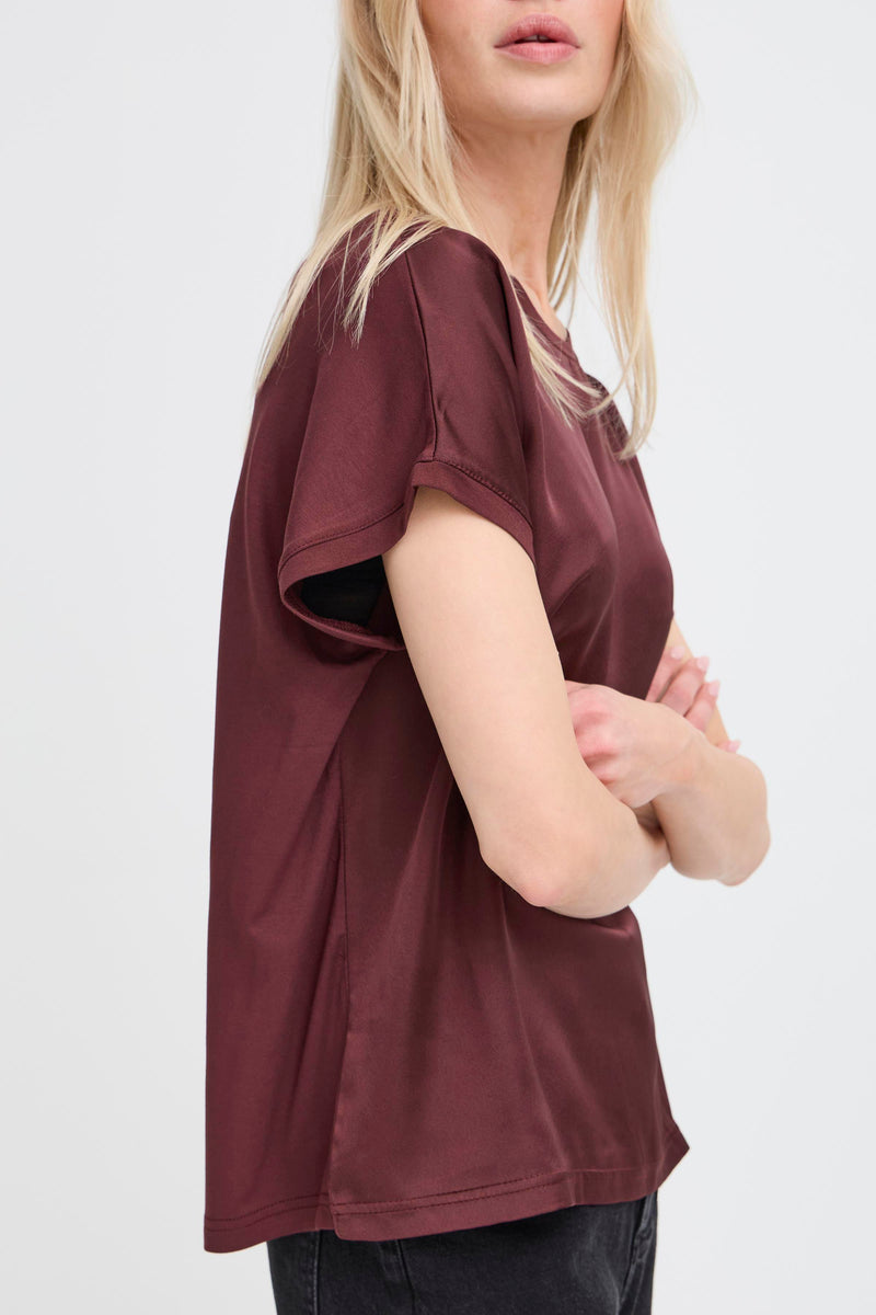 Person wearing a maroon t-shirt on a white background