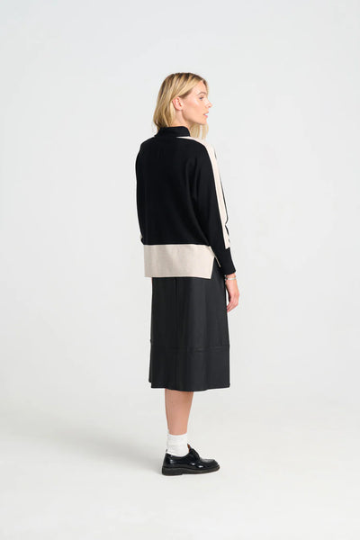 Woman wearing costamani rue black and beige jumper with a black skirt