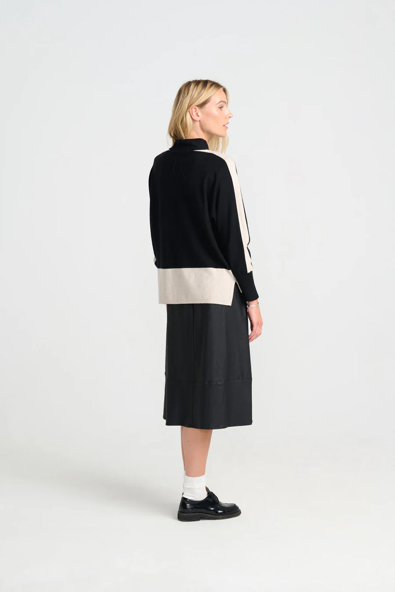 Woman wearing costamani rue black and beige jumper with a black skirt