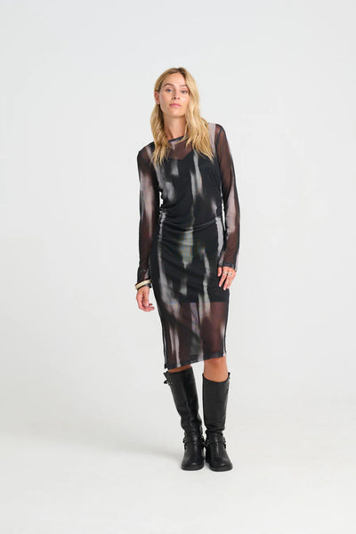 Woman wearing a costamani depp black brown mesh dress with long sleeves and black boots on a white background