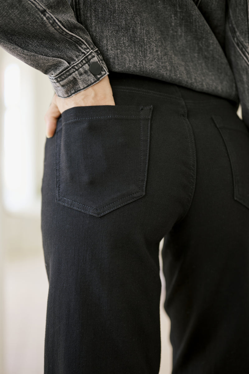 Person wearing black jeans with a blurred background