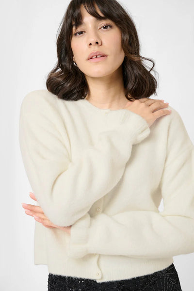 Woman wearing a cream sweater against a white background
