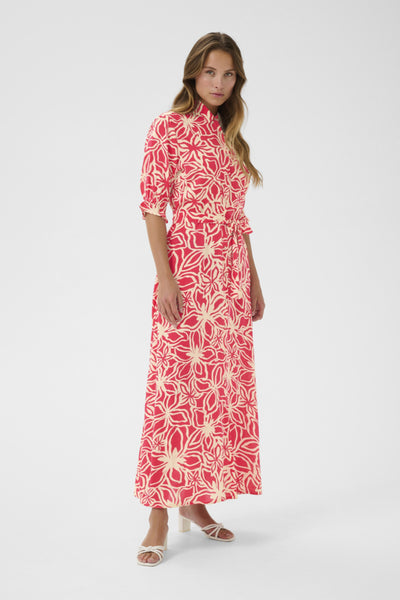 Front view of model wearing this long dress featuring button up front, collar, mid length sleeves and matching belt. Model is wearing low heels