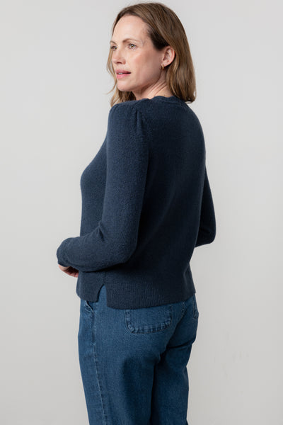 Woman wearing lily & Me navy sweater and jeans against a light gray background