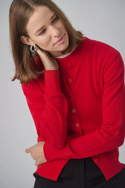 Woman wearing red Spina cardigan against a gray background