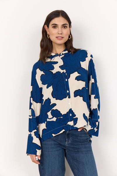 Woman wearing a blue and white floral blouse against a white background