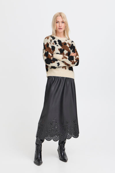 Woman wearing an animal print sweater and black skirt with lace details 
