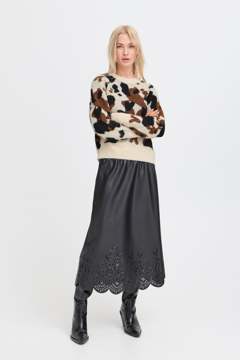 Woman wearing an animal print sweater and black skirt with lace details 
