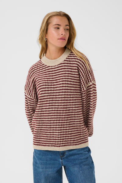 Woman wearing kaffe ellery pullover and jeans on a white background