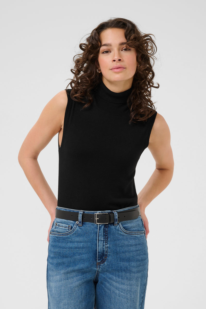Woman wearing kaffe black sleeveless top and blue jeans on a white background