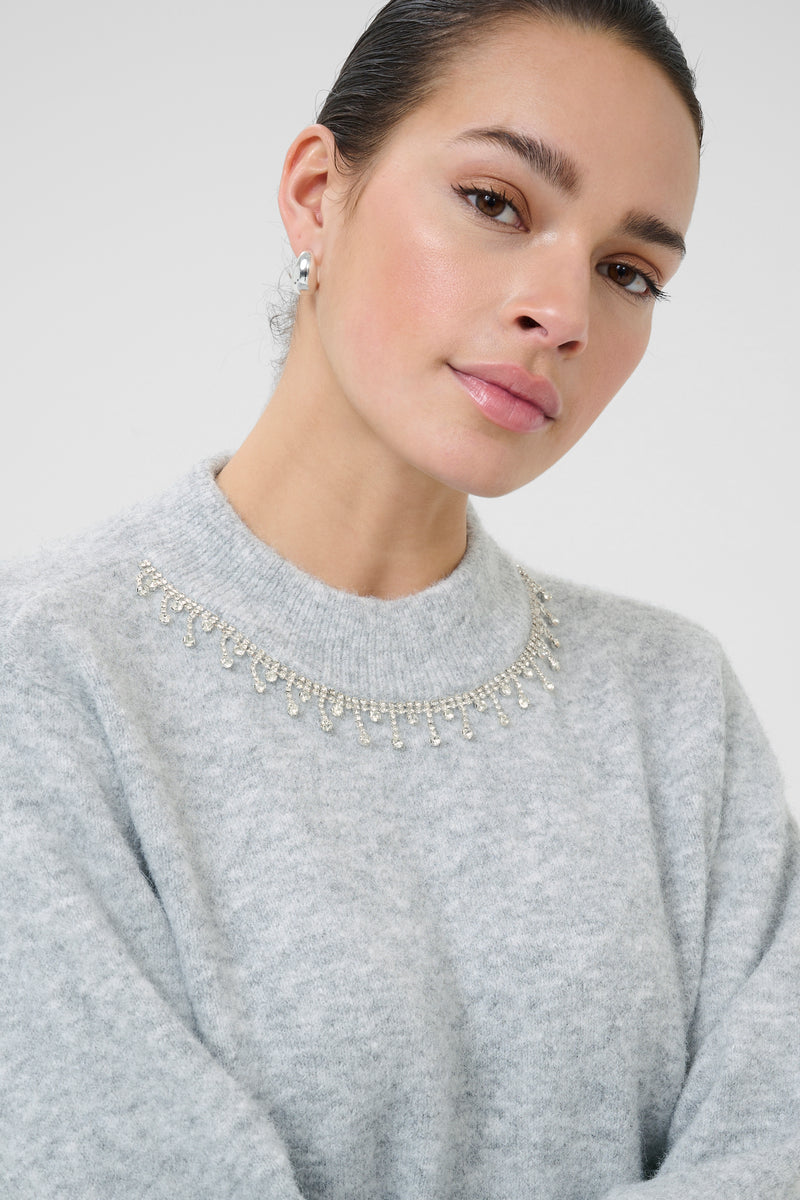 Woman wearing kaffe gray sweater with a decorative neckline 