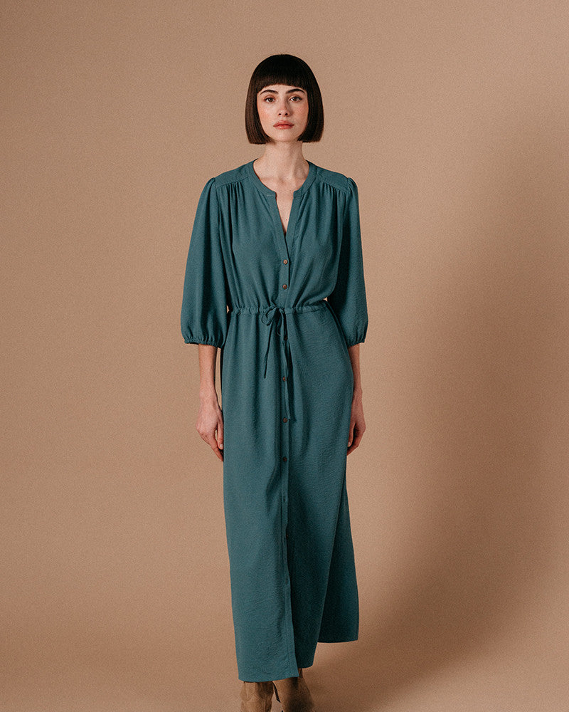 Watch your style take flight! The Laurence Maxi Dress by Grace & Mila is a dreamy blue vision of fashion. Featuring a relaxed fit, dusty teal hues, tie waist, and short puffed sleeves, it&