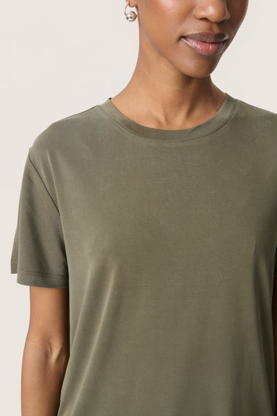 Person wearing a plain olive/khaki green t-shirt against a light background